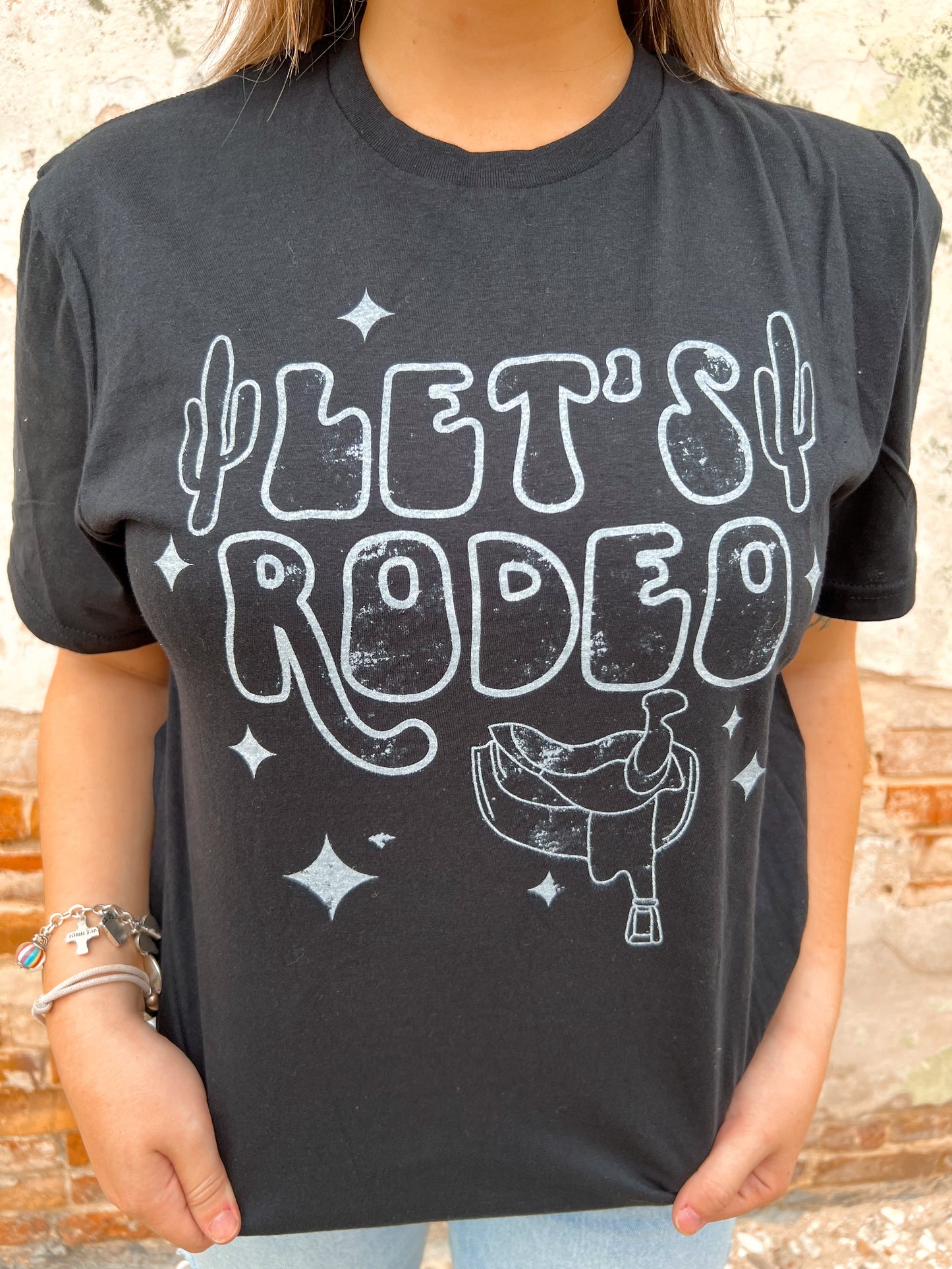 Let's Rodeo with stars and saddle - Black Tee-Top-the lattimore claim-09/12/23-The Twisted Chandelier